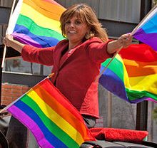 Jane Velez-Mitchell waving pride flags from a car