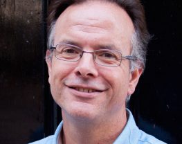 Headshot of David Clough smiling towards the camera.