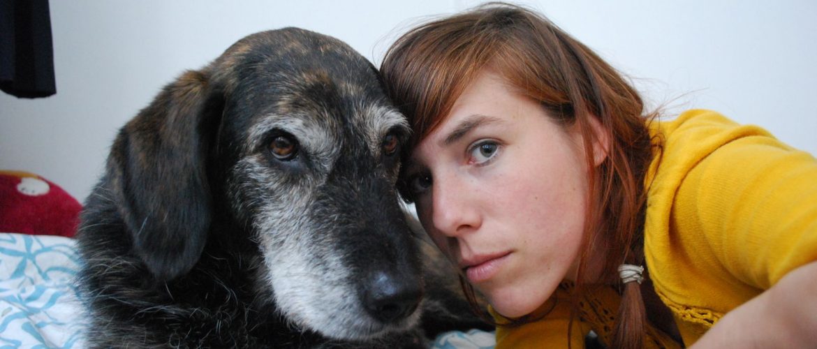 Picture of Eva Meijer and a canine friend looking towards the camera with their heads close together.