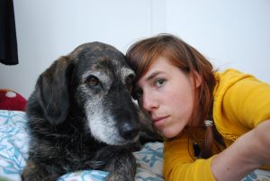 Picture of Eva Meijer and a canine friend looking towards the camera with their heads close together.